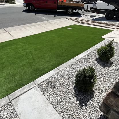 Front verge in artificial grass with a rock strip and clipped shrubs