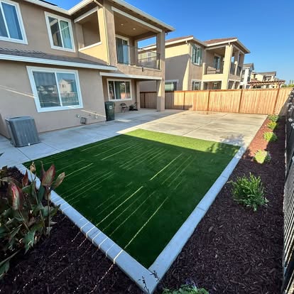 Front yard artificial grass lawn alongside a concrete driveway