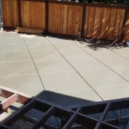 Large broom-finished backyard patio slab running the length of a fence line