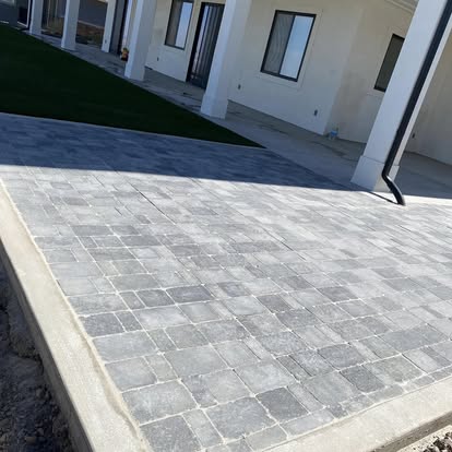 Interlocking paver patio laid over a compacted base beside a house