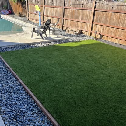 Artificial grass lawn laid beside a backyard pool