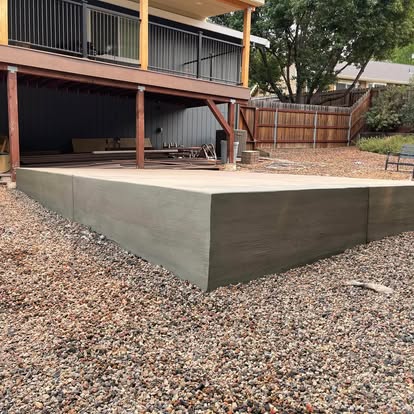 Raised concrete pad formed and poured beneath an elevated deck