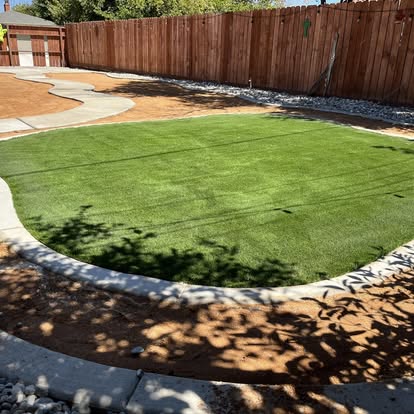 Rounded artificial grass lawn held by a poured concrete edge