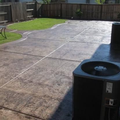Stamped and colour-finished concrete patio sweeping around the side of a house
