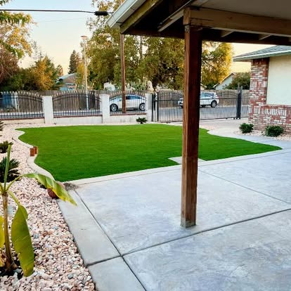 Artificial grass lawn beside a covered patio and concrete walkway