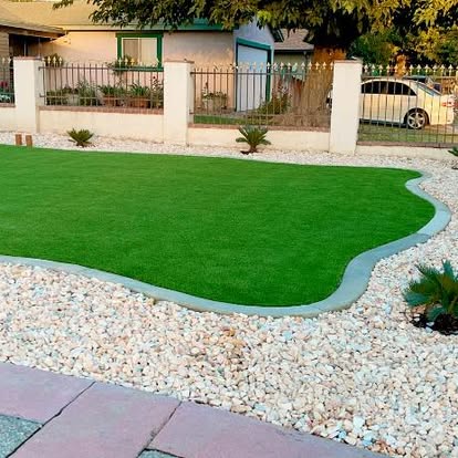 Front lawn in artificial grass with a curved white rock border