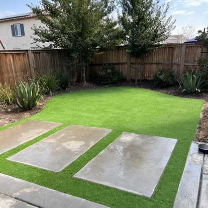 Artificial grass lawn with concrete stepping pads set into it