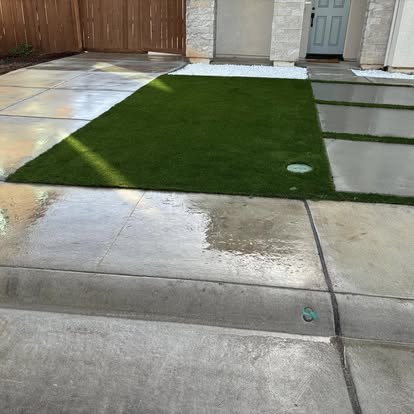 Artificial grass panel set between concrete flatwork at a front entry